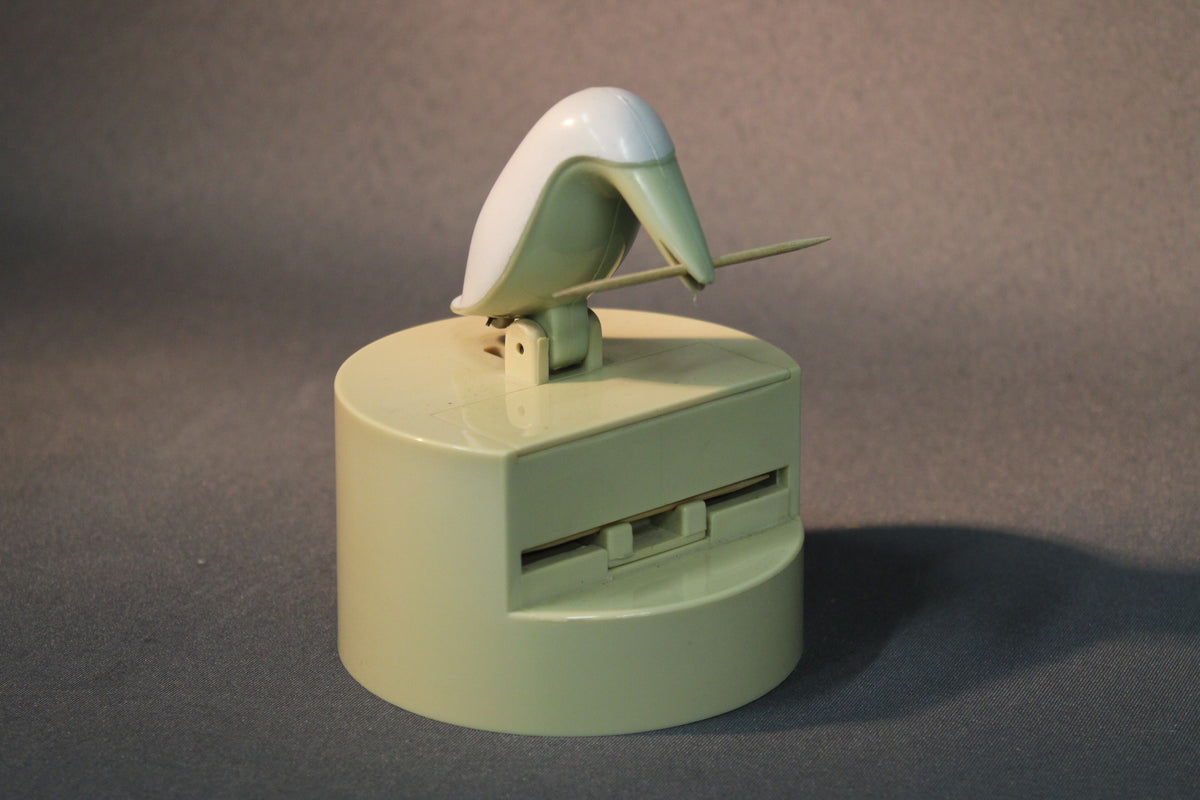 つまようじディスペンサーの使用例。鳥がつまようじを引き上げています。